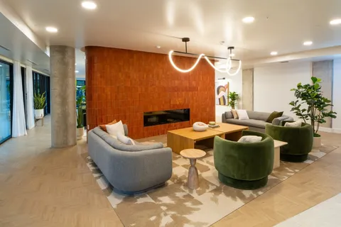 a living room with furniture a flat screen tv and a wall painting