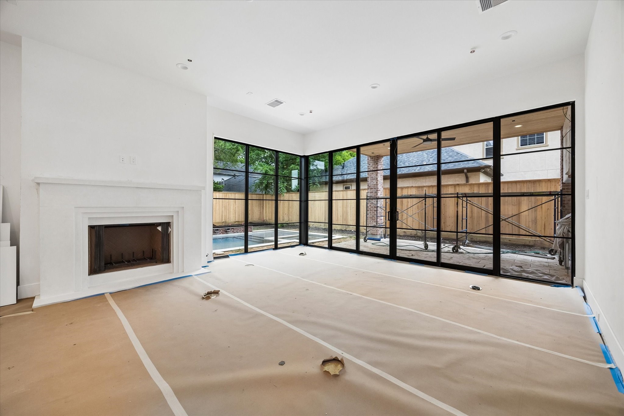 1328 Mickey Way Spring Valley Village, TX 77055 - Photo 4 of 26 Bright, open-concept living room with sliding doors and expansive corner windows that seamlessly connect to the outdoor living space. Covered outdoor kitchen to included gas grill and beverage refrigerator. Pictured April 2026.