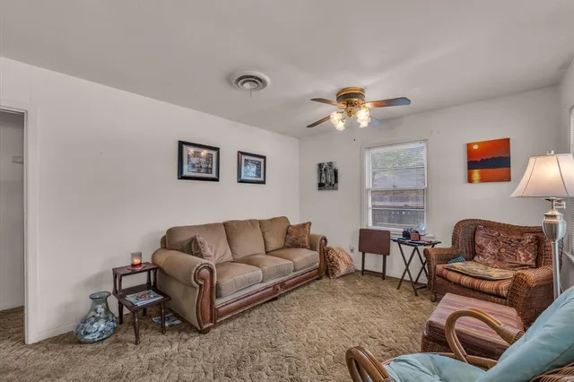 a living room with furniture and a ceiling fan