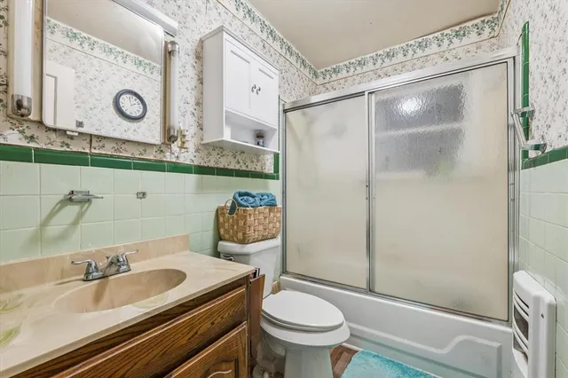 a bathroom with a granite countertop sink a toilet and shower