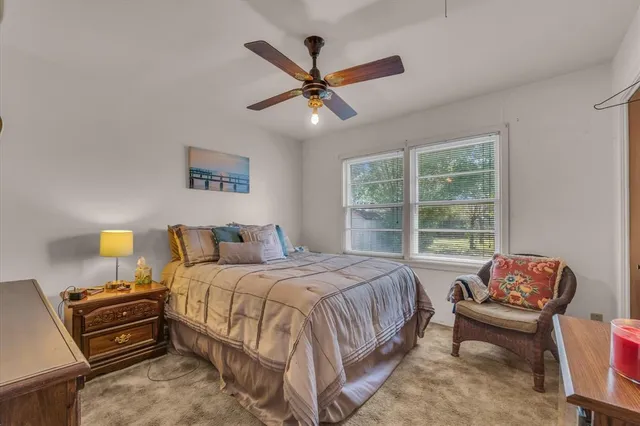 a bedroom with a bed couch and a large window