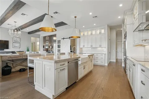 a kitchen with kitchen island granite countertop a sink a counter top space stainless steel appliances and cabinets