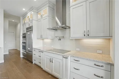 a kitchen with stainless steel appliances granite countertop a sink a stove and cabinets