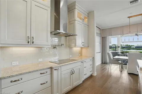 a kitchen with white cabinets and sink