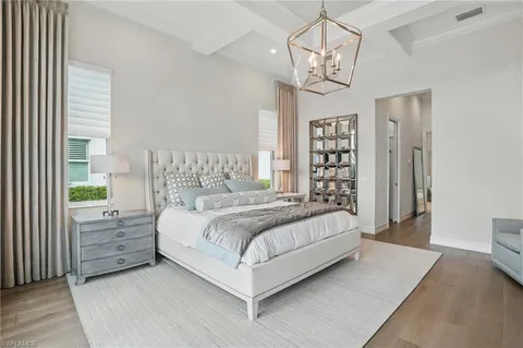 a bedroom with a large bed and a chandelier