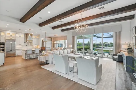 a room with lots of white furniture and a large window