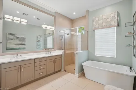 a bathroom with a granite countertop sink tub and mirror