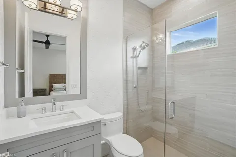 a bathroom with a sink toilet vanity and shower