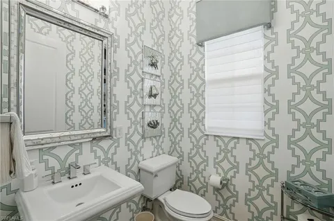 a bathroom with a sink and mirror with toilet