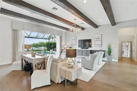 a living room with furniture a flat screen tv and a floor to ceiling window