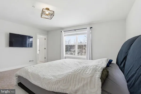 a bed sitting in a bedroom next to a window