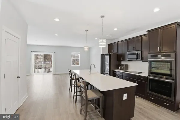 a kitchen with kitchen island a refrigerator stove microwave and cabinets