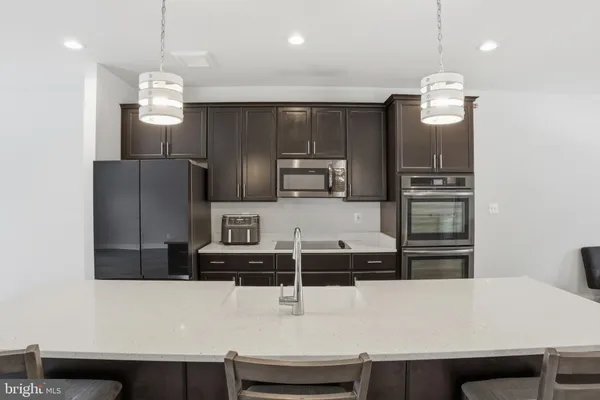 a kitchen with kitchen island a counter top space cabinets and stainless steel appliances
