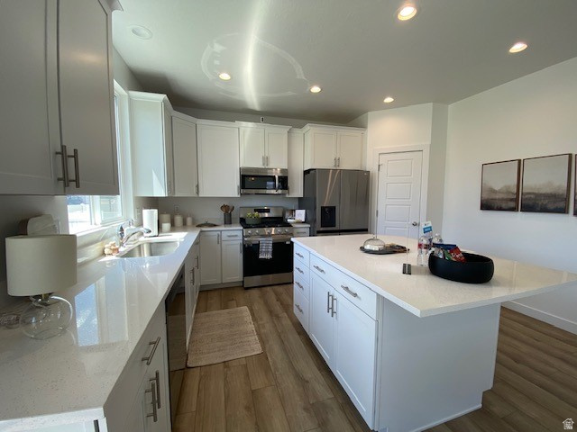 341 Quartz Road, Unit 8037 Tooele, UT 84074 - Photo 10 of 10 Modern kitchen featuring an expansive island with white cabinetry, ample counter space, stainless steel appliances, wood-finish flooring, and recessed lighting