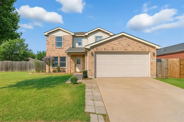 a view of a big house with a big yard and large trees