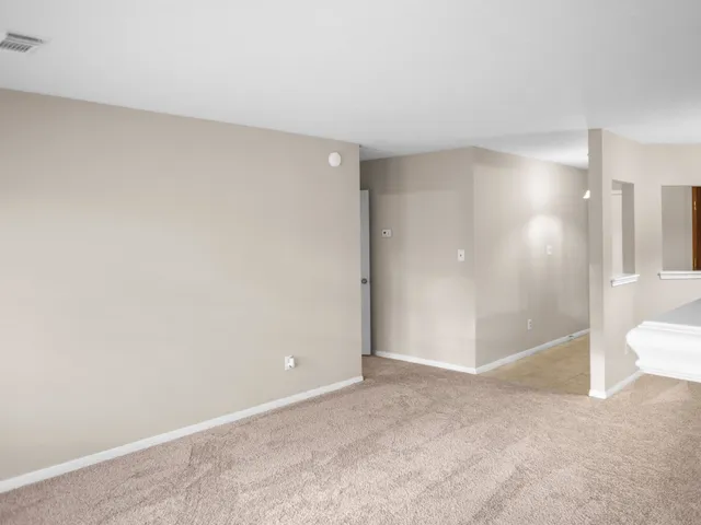 a view of a livingroom with a chandelier fan and windows
