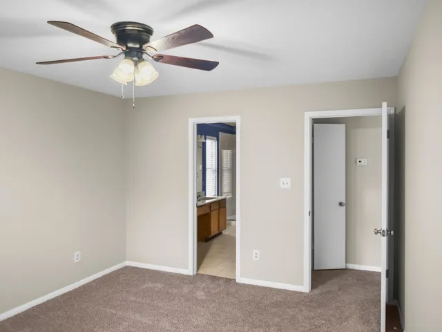 an empty room with a window and a fan