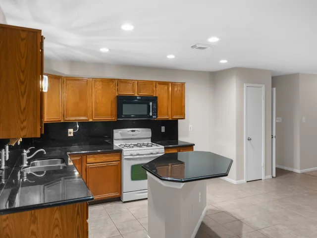 a kitchen with stainless steel appliances granite countertop a sink stove and cabinets