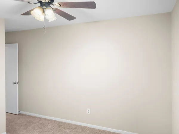 a view of an empty room with window and a fireplace