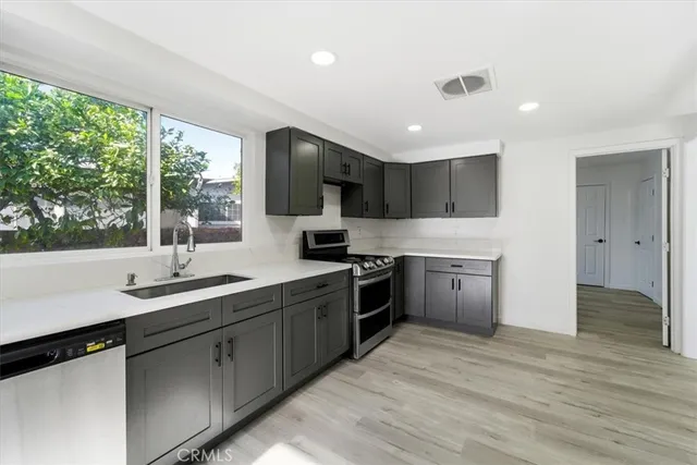 a kitchen with stainless steel appliances granite countertop a stove a sink and a refrigerator