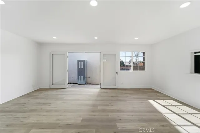 a view of a big room with wooden floor and windows