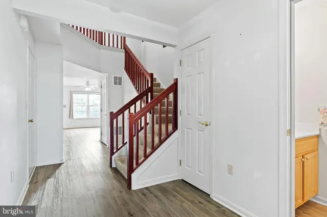 a view of a hallway with wooden floor and staircase