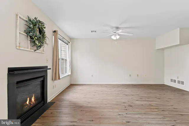 an empty room with windows and fireplace