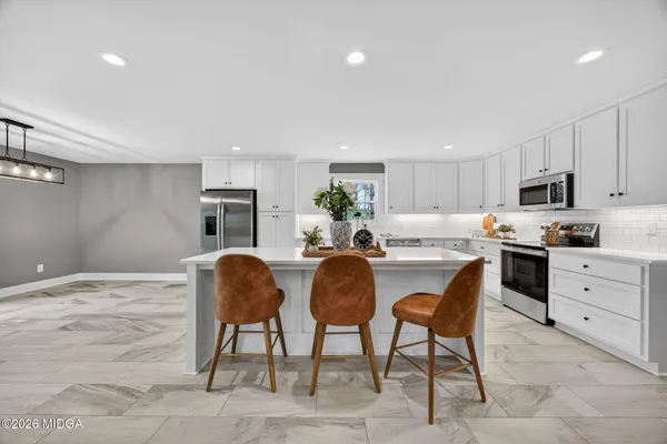 a kitchen with granite countertop a sink cabinets and stainless steel appliances