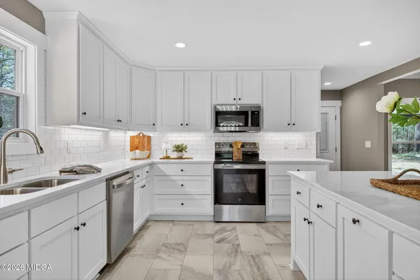 a kitchen with cabinets stainless steel appliances and a sink