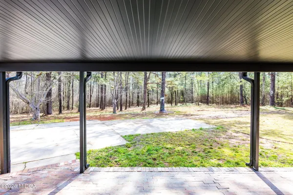 a view of a porch with a table and chairs and floor to ceiling window