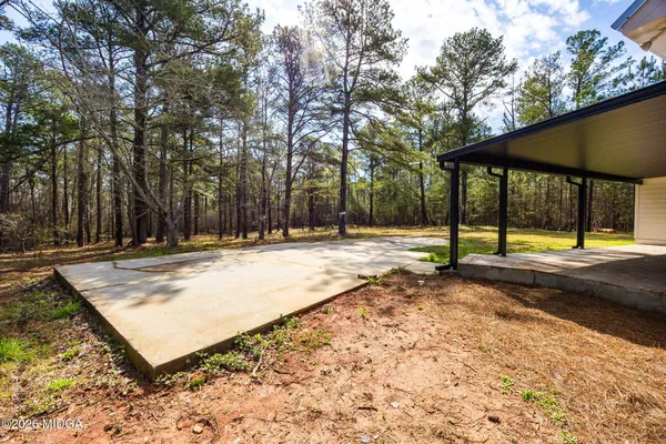 a view of a house with backyard and a tree