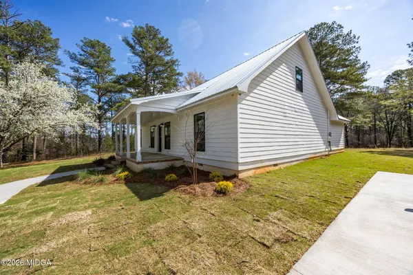 a view of a house with backyard and sitting area