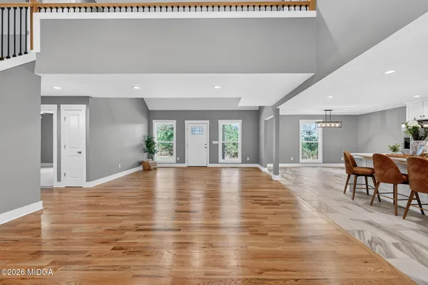 a view of an empty room with window and wooden floor
