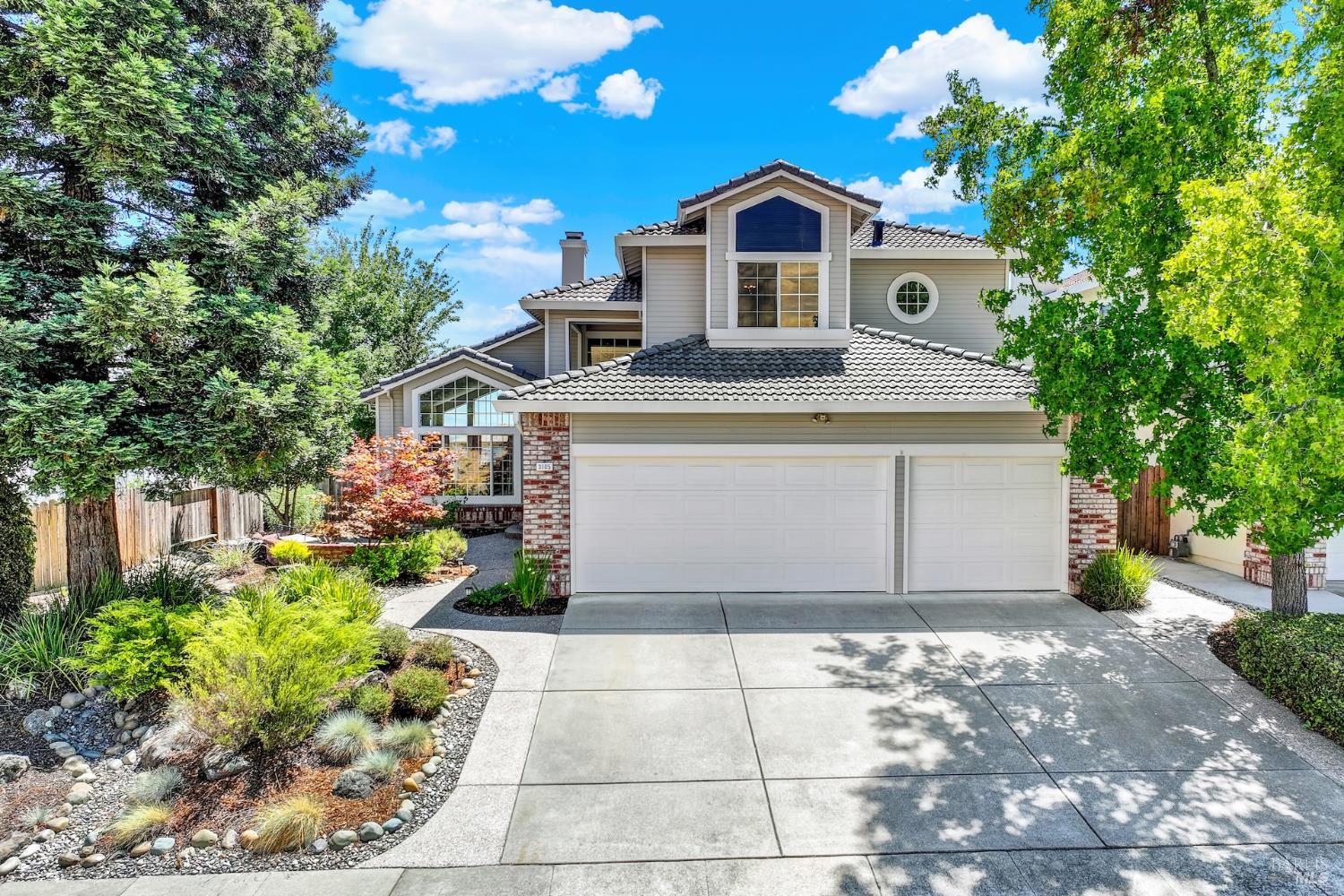 a front view of a house with a yard and trees