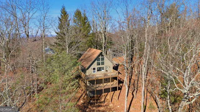 a view of a big house with a big yard and large trees