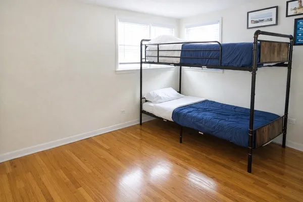 a bedroom with a bed window and wooden floor