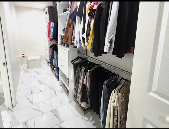 a view of walk in closet with clothes and shoes