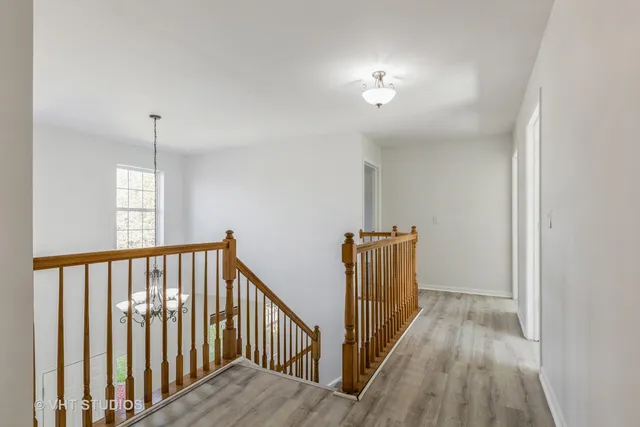 a view of a hallway with wooden floor and staircase
