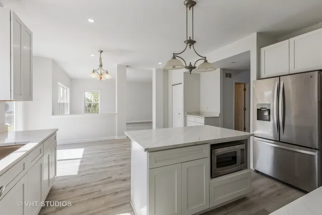 a kitchen with stainless steel appliances a kitchen island a stove a refrigerator and a sink