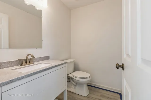 a bathroom with a granite countertop toilet a sink and mirror