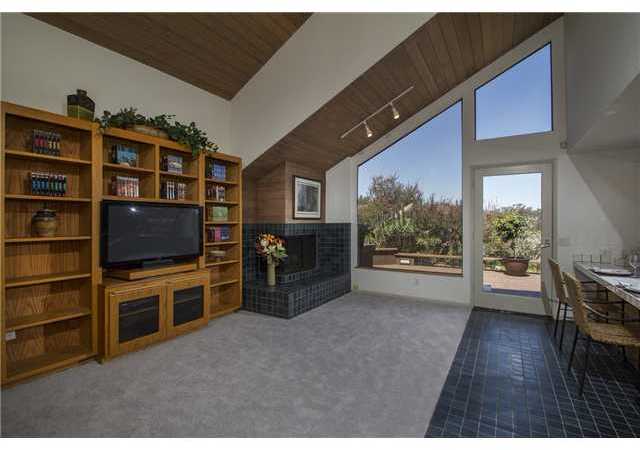 4920 Rancho Grande Del Mar, CA 92014 - Photo 11 of 25 The den off the kitchen has a fireplace and doors which lead onto one of the many deck areas surrounding the residence for Callifornia indoor/outdoor living at it's best.