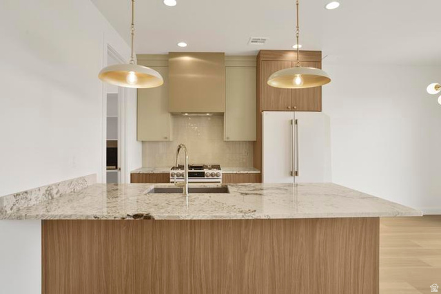 990 Manen Street Washington, UT 84780 - Photo 5 of 43 Kitchen island featuring a substantial stone countertop, integrated sink with a gooseneck faucet, and wood-finish paneling
