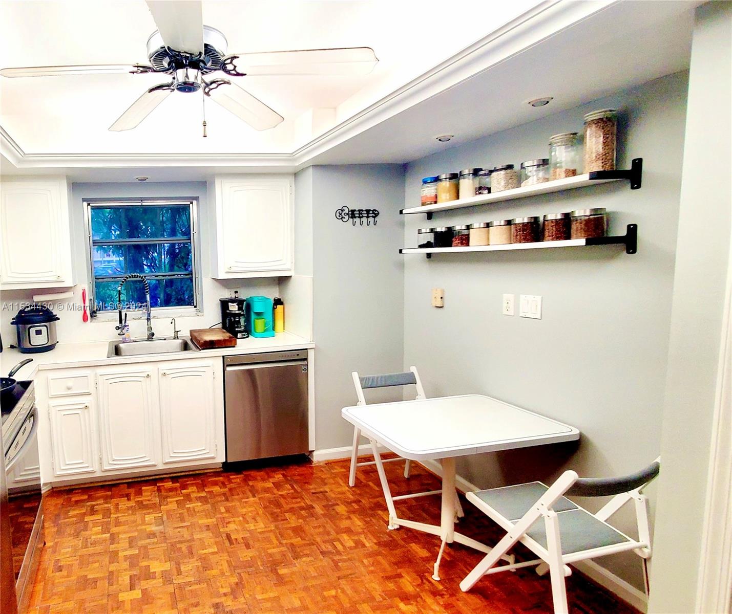 a kitchen with a dining table chairs and white cabinets