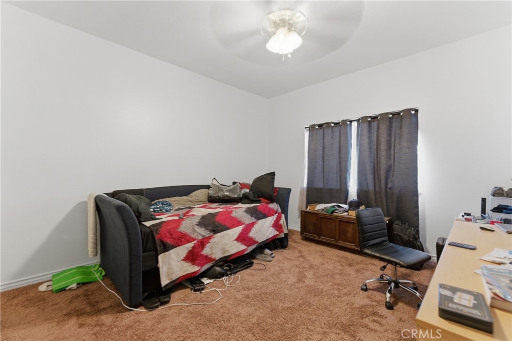 11368 Cactus Avenue Bloomington, CA 92316 - Photo 18 of 32 a bedroom with a bed and a chandelier