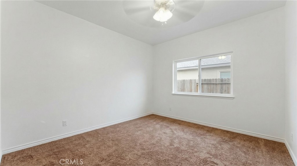11368 Cactus Avenue Bloomington, CA 92316 - Photo 19 of 32 an empty room with a chandelier fan