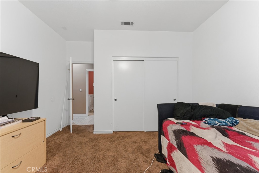 11368 Cactus Avenue Bloomington, CA 92316 - Photo 21 of 32 a bedroom with a bed and a flat screen tv