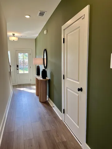 a view of entryway and hall with wooden floor