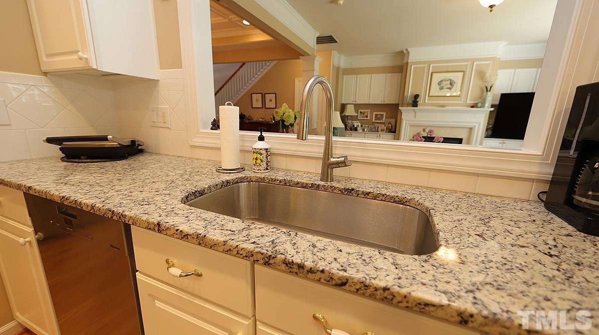 3621 Lion Ridge Court Raleigh, NC 27612 - Photo 12 of 34 a kitchen with granite countertop a sink and a stove top oven