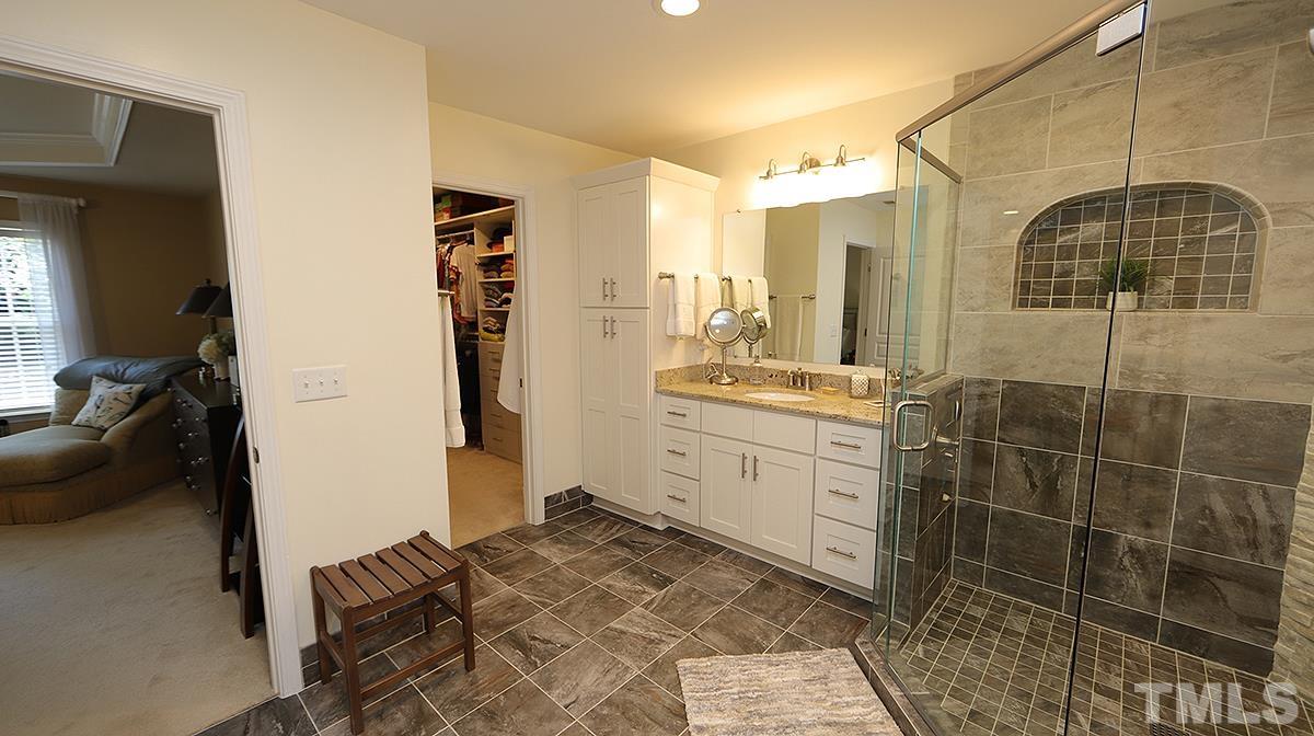 3621 Lion Ridge Court Raleigh, NC 27612 - Photo 25 of 34 a bathroom with a granite countertop sink a mirror and shower