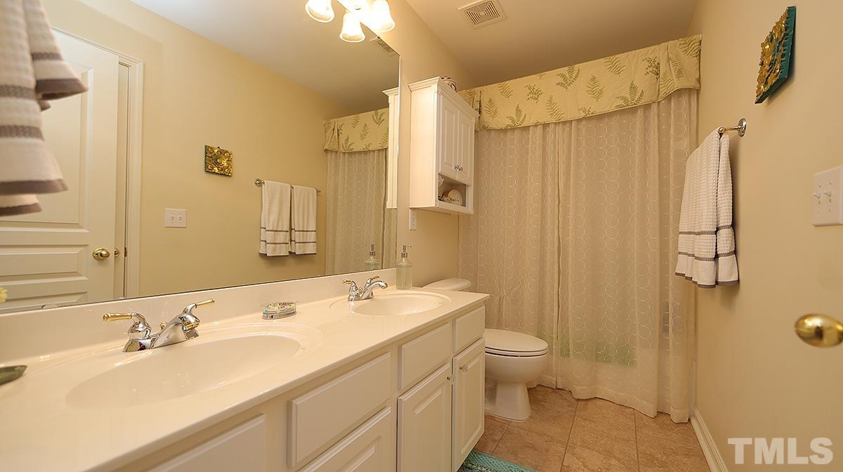 3621 Lion Ridge Court Raleigh, NC 27612 - Photo 31 of 34 a bathroom with a sink a toilet and a mirror